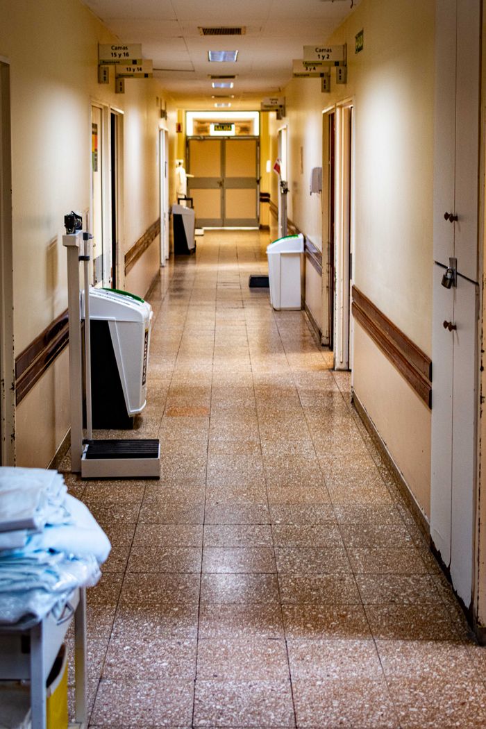 About A quiet, empty hospital corridor with medical equipment and a scale.